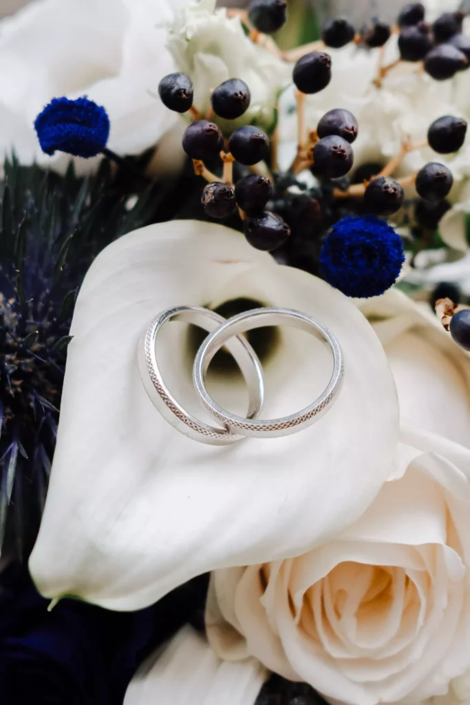 Photographe mariage Éghezée – alliances posées sur bouquet de mariée au Château Bayard
