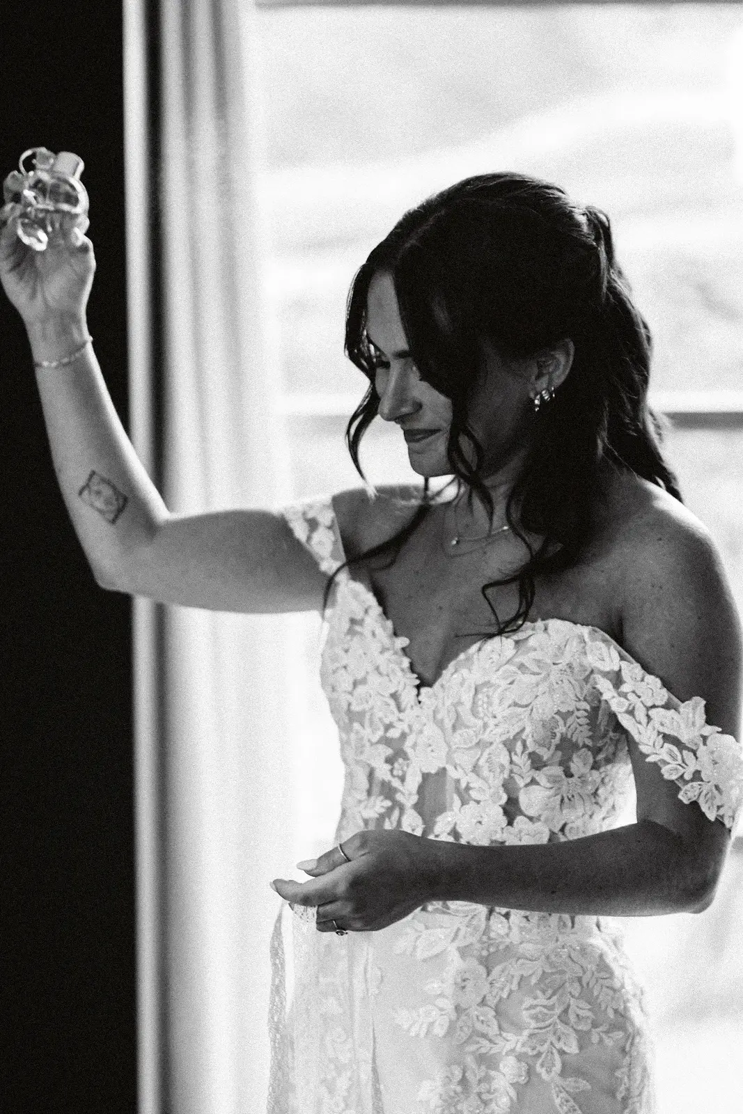 Mariée devant la fenêtre en lumière naturelle, noir et blanc